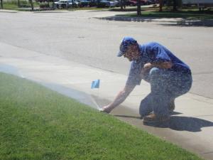 an Antioch Sprinkler Repair tech adjusts a pop up head
